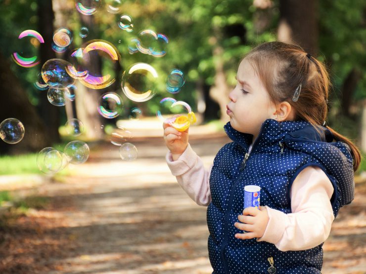 Ein Kind spielt mit Seifenblasen.