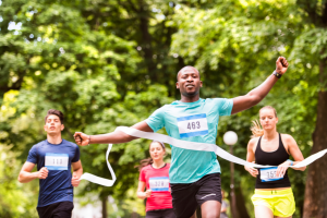 Mann läuft durch Ziellinie - Tipps fürs Durchhalten - nicht nur beim Sport