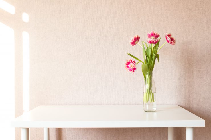 Ein Strauß Tulpen steht auf einem weißen Tisch - Minimalismus.