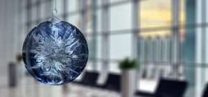 Blaue Christbaumkugel vor Bürohintergrund - Auszeichnungen für Raiffeisen Capital Management und Jahresrückblick-Gedanken