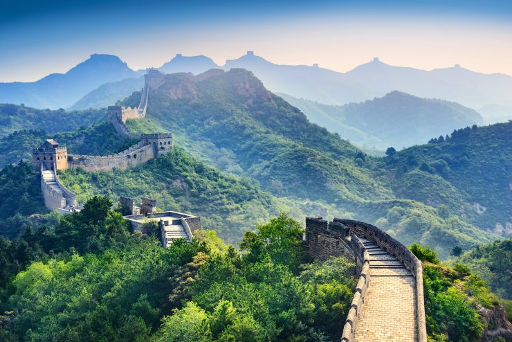 Das Bild zeigt die Chinesische Mauer eingebettet in grüne Hügel - Corona-Virus.