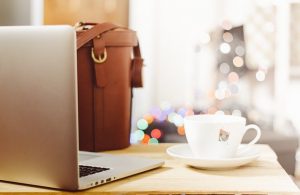 Laptop mit Kaffeetasse und Tasche - Weiterentwicklung Beruf