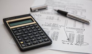 Taschenrechner und Kugelschreiber - Dinge, die wir zuhause für unser Geld tun können: einen Haushaltsplan erstellen