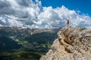 Frau blickt vom Gipfel des Berges - sich Ziele setzen in allen Lebensbereichen