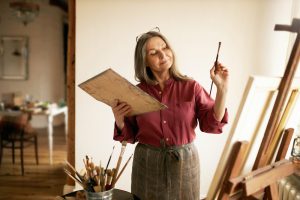 Frau malt in der Küche - alte Hobbies wieder entdecken im Urlaub zuhause