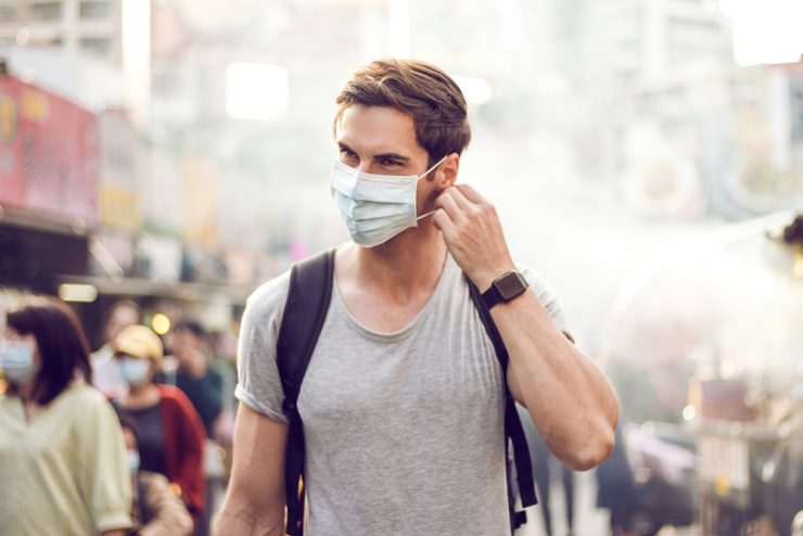 Optimismus durch Entspannung bei Pandemie - Mann mit Covid-19-Maske auf der Straße
