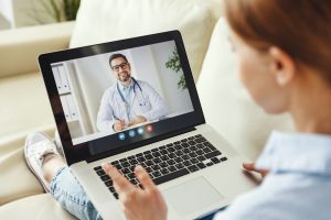 Eine Frau spricht via Laptop mit einem Arzt.