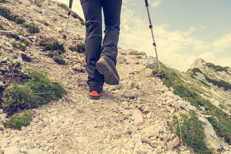 Das Bild zeigt die Beine eines Wanderers beim Besteigen eines Berges. Ein Synonym für den Aufwärtstrend in der Weltwirtschaft.