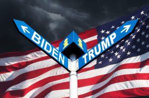 Vor der amerikanischen Flagge sind zwei Wegweise mit den Kontrahenten der US-Wahl: Trump vs. Biden.