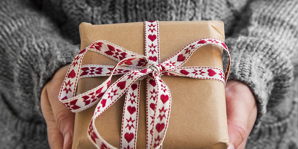 Frau hält Geschenk in Händen - originelle nachhaltige Weihnachtsgeschenke - das etwas andere Weihnachtsgeschenk hier zu finden