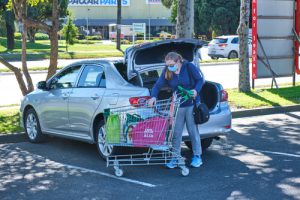 Frau lädt überfüllten Einkaufswagen ins Auto - Amerika als Konsummacht ist Thema im Wahlprogramm