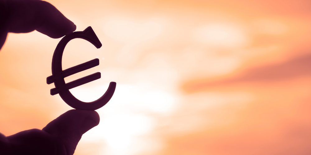 Weiterhin unterstützende Geldpolitik zugesagt - Hand hält Eurozeichen im Sonnenschein