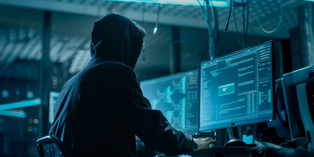 Mann hackt Computer, Cyber Security wird durch Digitalisierung ein Wachstumsmarkt