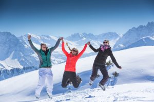 3 Personen im Schnee stehen für Österreich, Deutschland und Schweiz