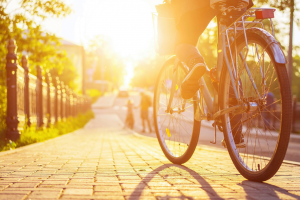 Ein Fahrradfahrer in der Stadt der im Sonnenschein zur gemeinsamen Wohnung fährt.