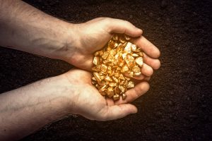 Im Bild sind zwei Hände voll Goldnuggets zu sehen. Gold war 2020 neben Investmentfonds auch eine Anlagemöglichkeit.