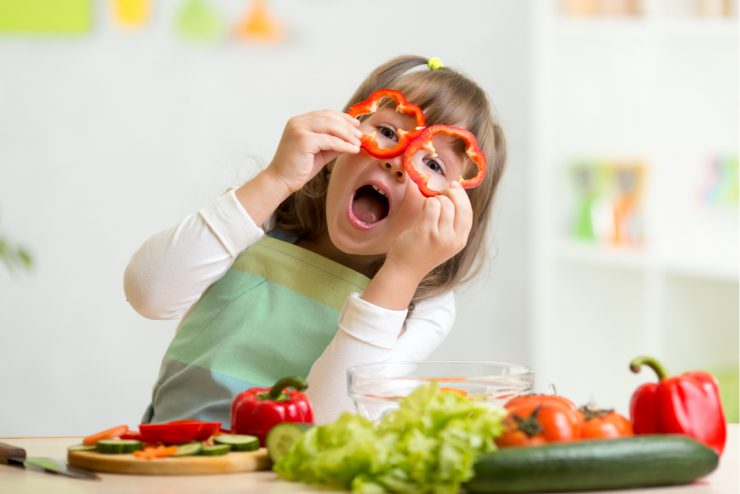 Kind mit Gemüse - Kinder in den Ferien nachhaltig beschäftigen