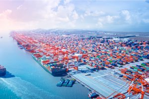 Blick über China und das Meer - ein Handelsschiff verlässt den Hafen