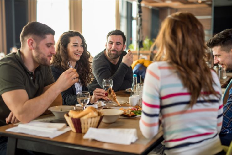 Gäste sitzen im Restaurant - Öffnungen führen zu Aufholjagd und Boom in der Wirtschaft