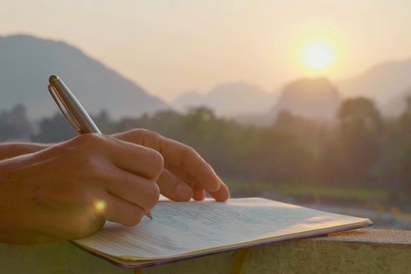 Frau schreibt vor Sonnenaufgang - durch Schreiben zu mehr Klarheit