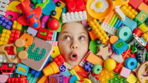 Kind schaut inmitten von Spielzeug-Legoberg hervor - das etwas andere Weihnachtsgeschenk finden