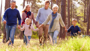 Großeltern mit Kindern und Enkelkindern gehen in der Natur spazieren
