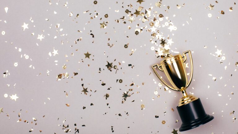 Ein goldener Pokal mit goldenen Glitzersternchen zu sehen - tolle Awards für die Raiffeisen KAG