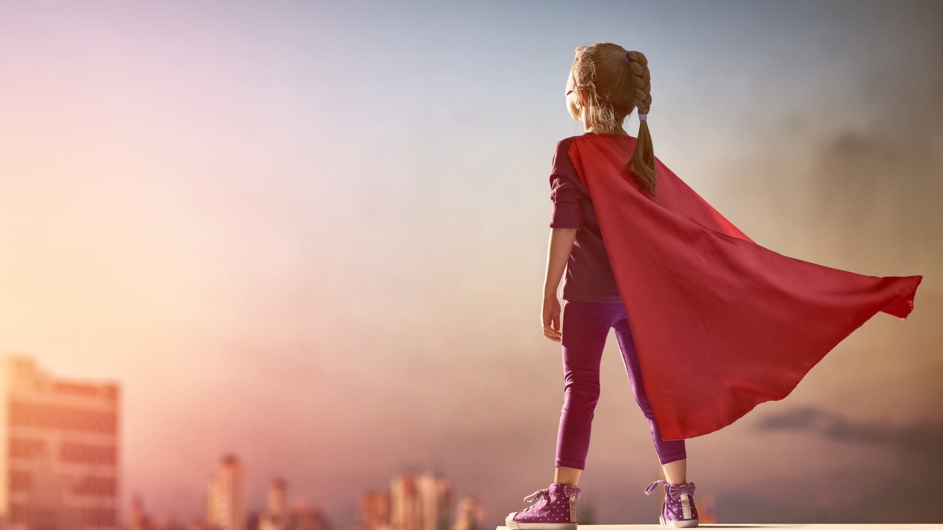 Frauen und Mädchen sollen selbstbestimmt handeln - zu sehen ein Maedchen in Superwoman-Montur