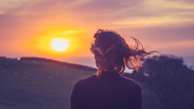 Frau blickt in den Sonnenuntergang - welcher Krisentyp bist du?