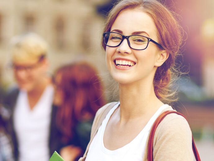 Junge Frau mit Brille und Studentenmappe - sie nutzt den Durchschnittskosteneffekt
