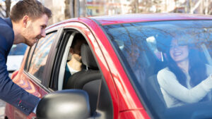 Frau lädt Mann ins Auto ein - Fahrgemeinschaften bilden ist eine Ersparnis gegen Preiserhöhungen