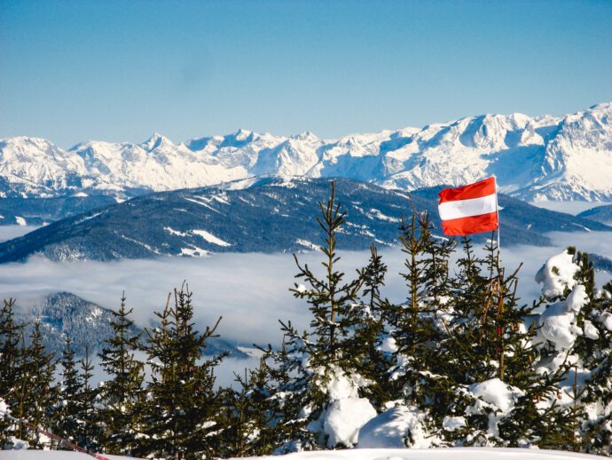 Österreich Flagge vor Winterpanorama - Keine Panik bei österreichischen Staatsanleihen