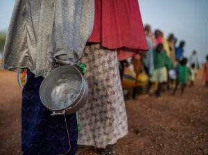 Eine Frau hält einen leeren Topf - Spenden gegen Welthunger