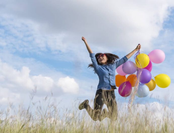 Eine Frau springt mit Luftballons in die Luft - finde statt dem Vorsatz deinen Wunsch