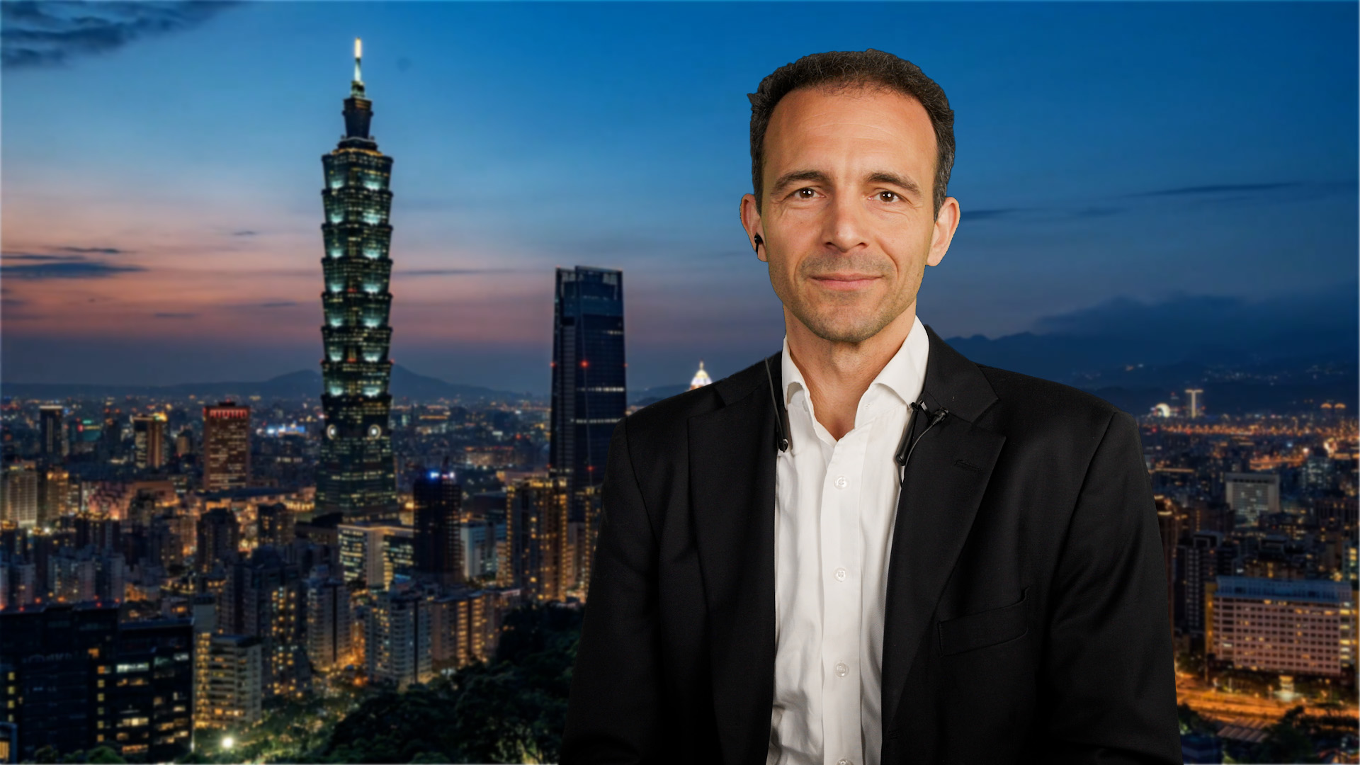 Fondsmanager Leopold Quell vor der nächtlichen Skyline Taipehs, der Hauptstand von Taiwan.