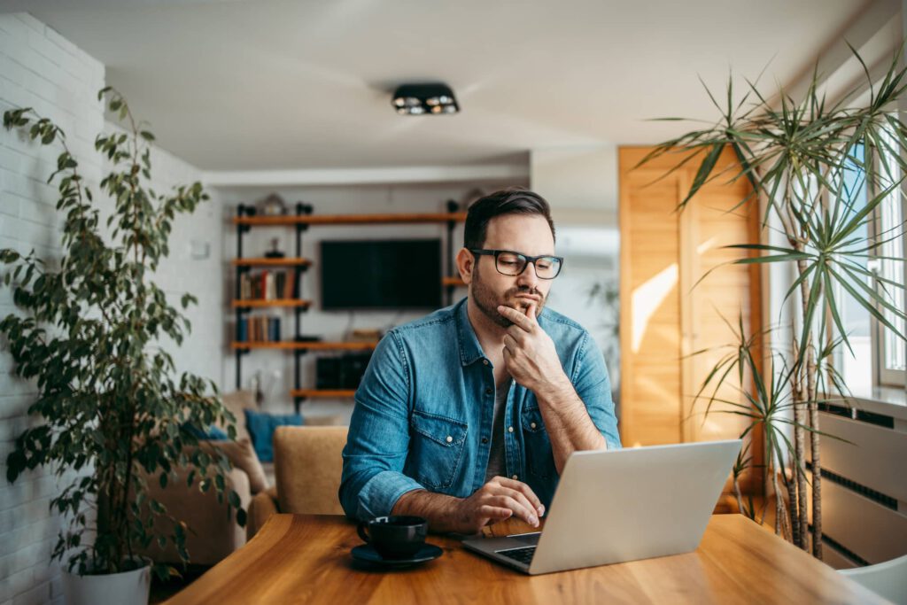 Ein Mann sitzt nachdenklich vor dem Laptop - reichen höhere Zinsen für das Anlage-Glück? Mix mit Anleihen?