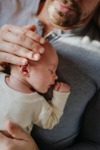 Mann mit Baby im Arm sorgt für sein Kind vor