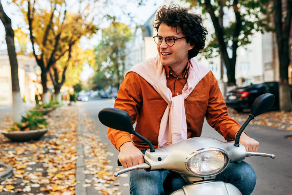 Mann sitzt auf Moped - mit dem Kickstarter geht es schneller