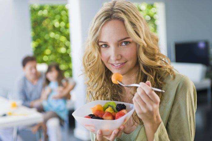 Frau isst Obstsalat - ähnelt einem Fonds