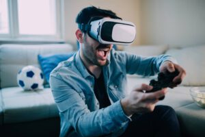 Ein junger Mann spielt mit einer VR-Brille auf einer Console.