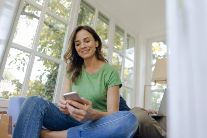 Frau mit Handy abonniert den Newsletter