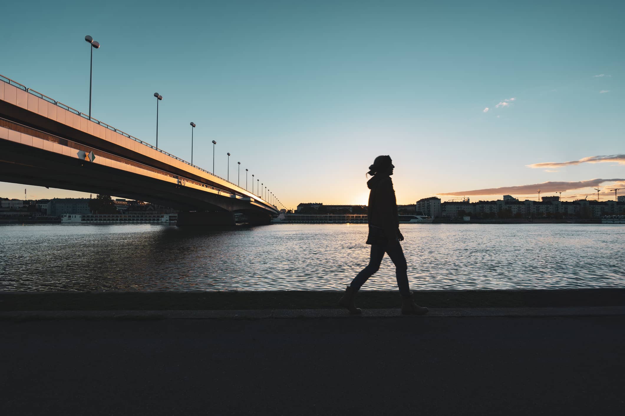 Eine Frau geht unter einer Brücke - investieren in Infrastruktur