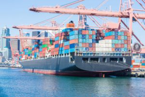 Am Bild ist ein Containerschiff zu sehen. Sinnbild aus die Auswirkungen Trumps Zollpolitik auf Waren.