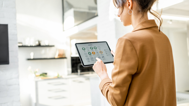 Eine Frau in einer Wohnung erstellt ihren Haushalts-Plan mit einer App